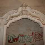 In una di esse spicca un maestoso arco decorativo in rilievo in gesso bianco, anch'esso deturpato da un orrendo scarabocchio